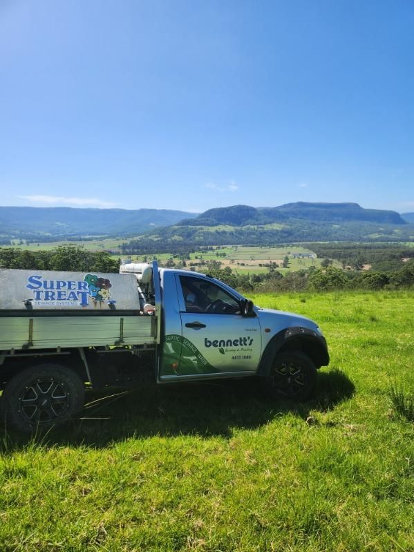 A White Truck is Parked in a Grassy Field — Bennett's Servicing and Plumbing In South Nowra, NSW