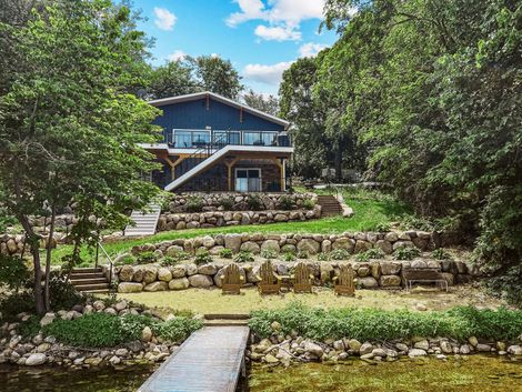 Lakefront house with tiered landscaping and dock.