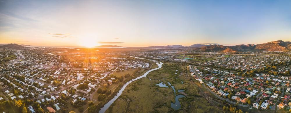 An Aerial View of a City at Sunset With a River Running Through It — Bargara Removals in Gin Gin, QLD