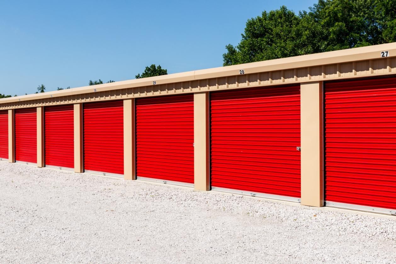 Row of Red Garage Doors Are Lined Up in a Parking Lot — Bargara Removals in Agnes Waters, QLD