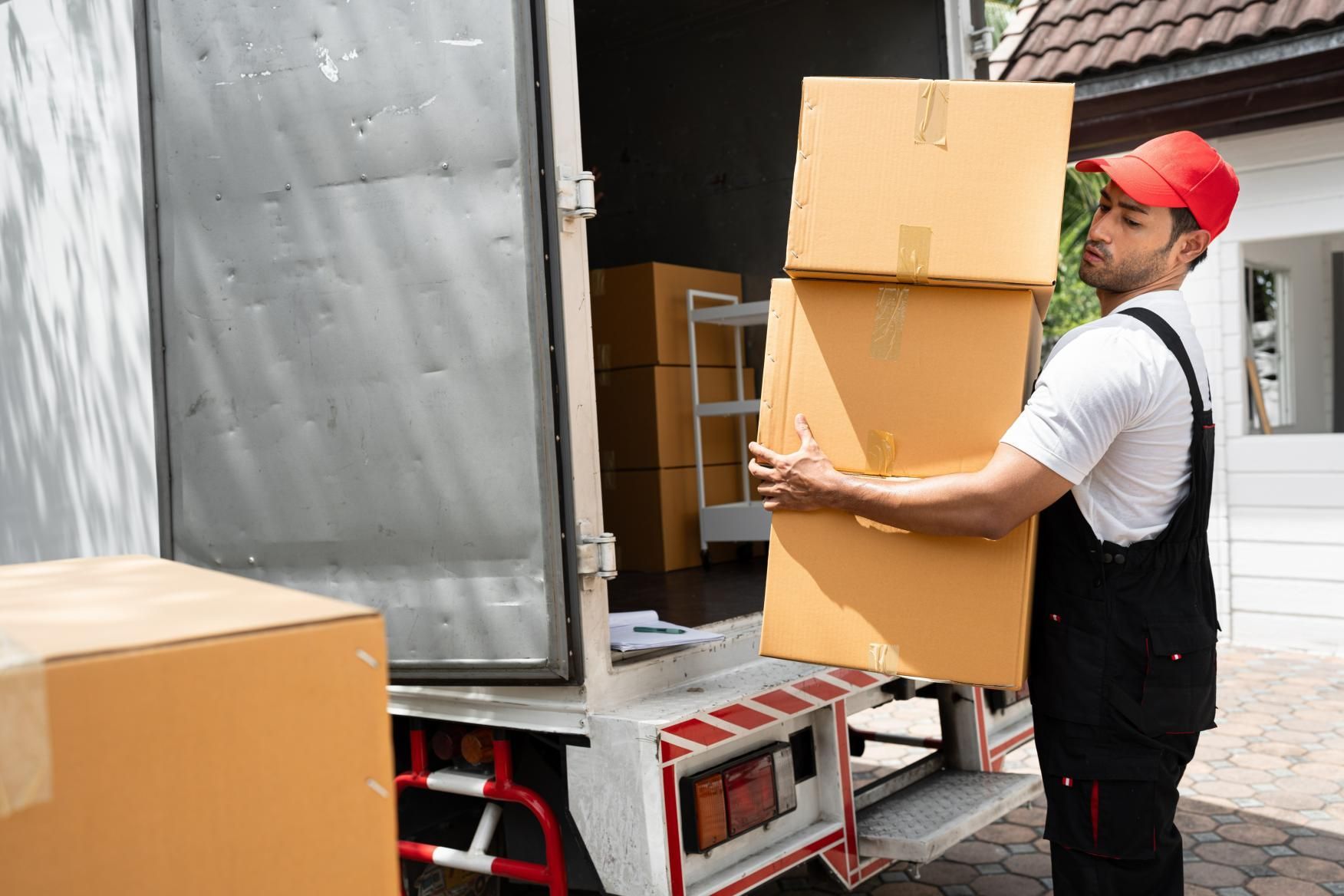 Man is Carrying Boxes Out of a Moving Truck — Bargara Removals in Bargara, QLD