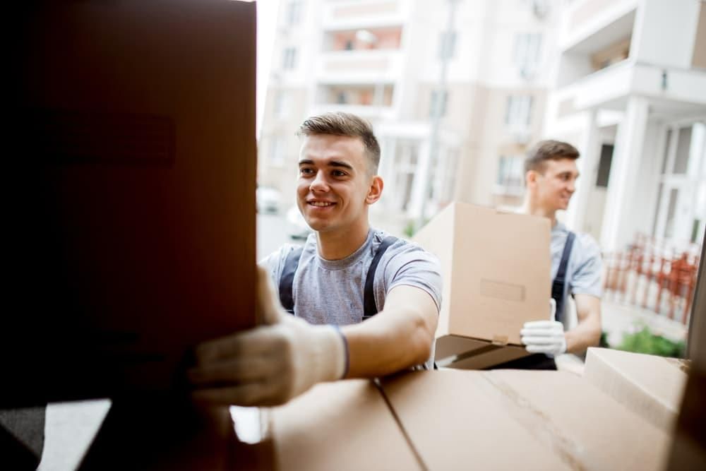 Man is Holding a Cardboard Box in His Hands — Bargara Removals in Rubyanna, QLD