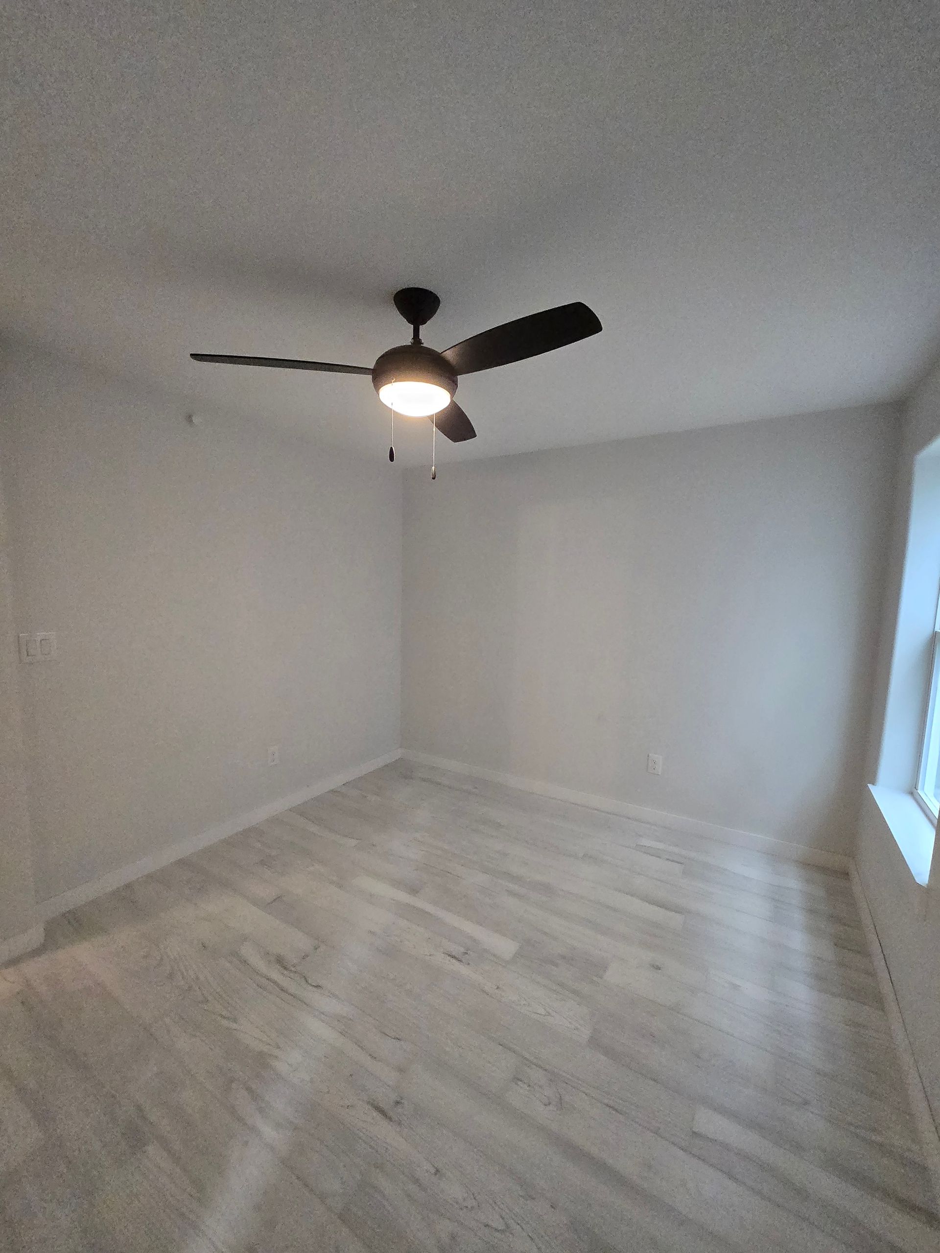 There is a ceiling fan in the corner of the room.