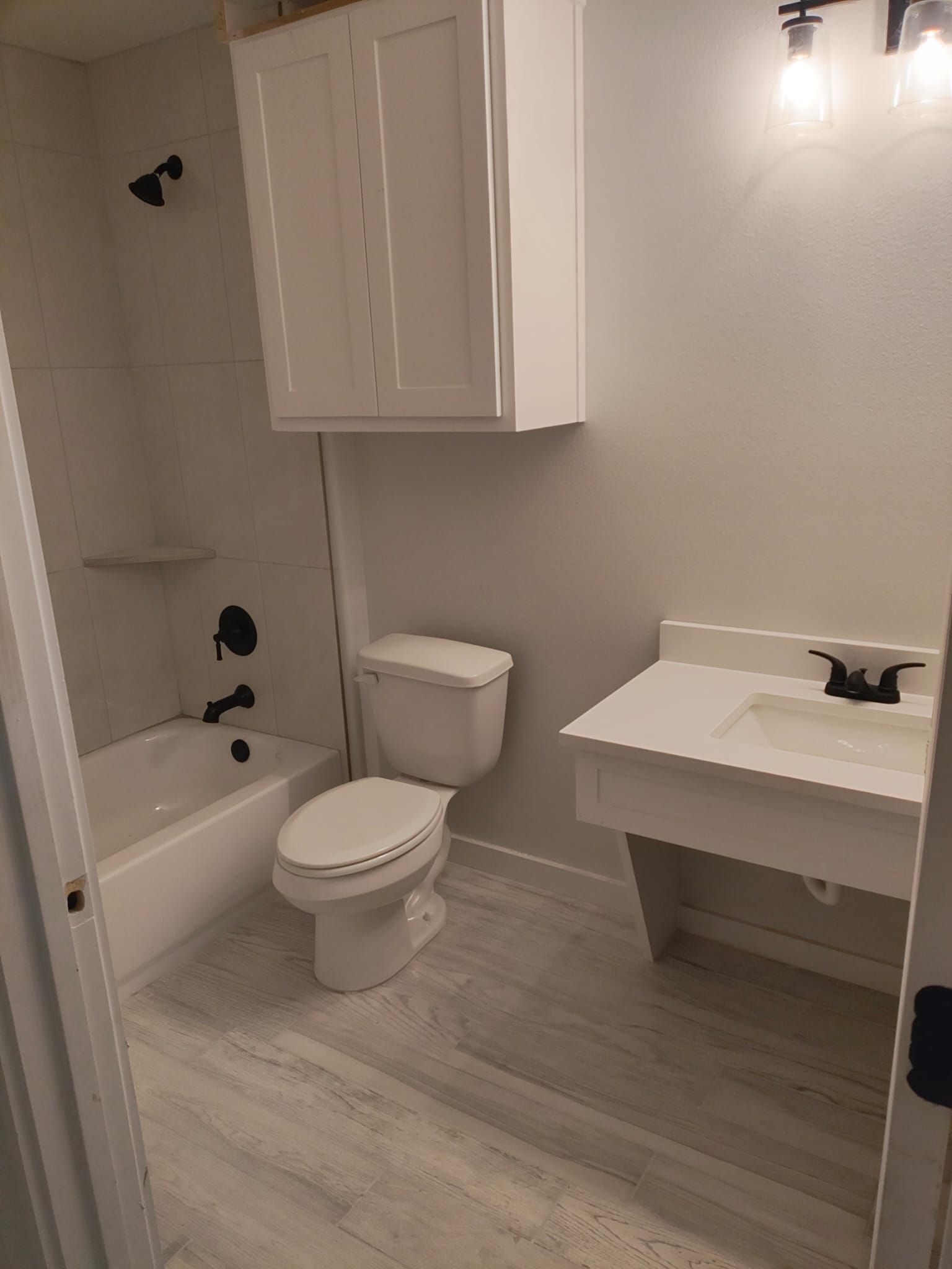 A bathroom with a toilet , sink , bathtub and shower.