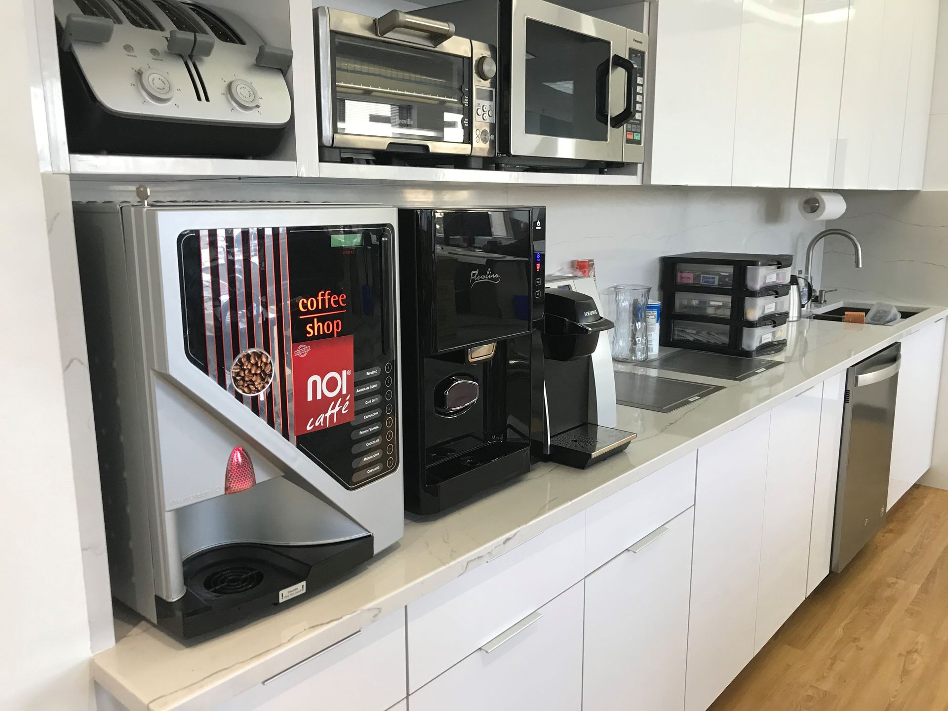 A kitchen with a coffee machine and a microwave.