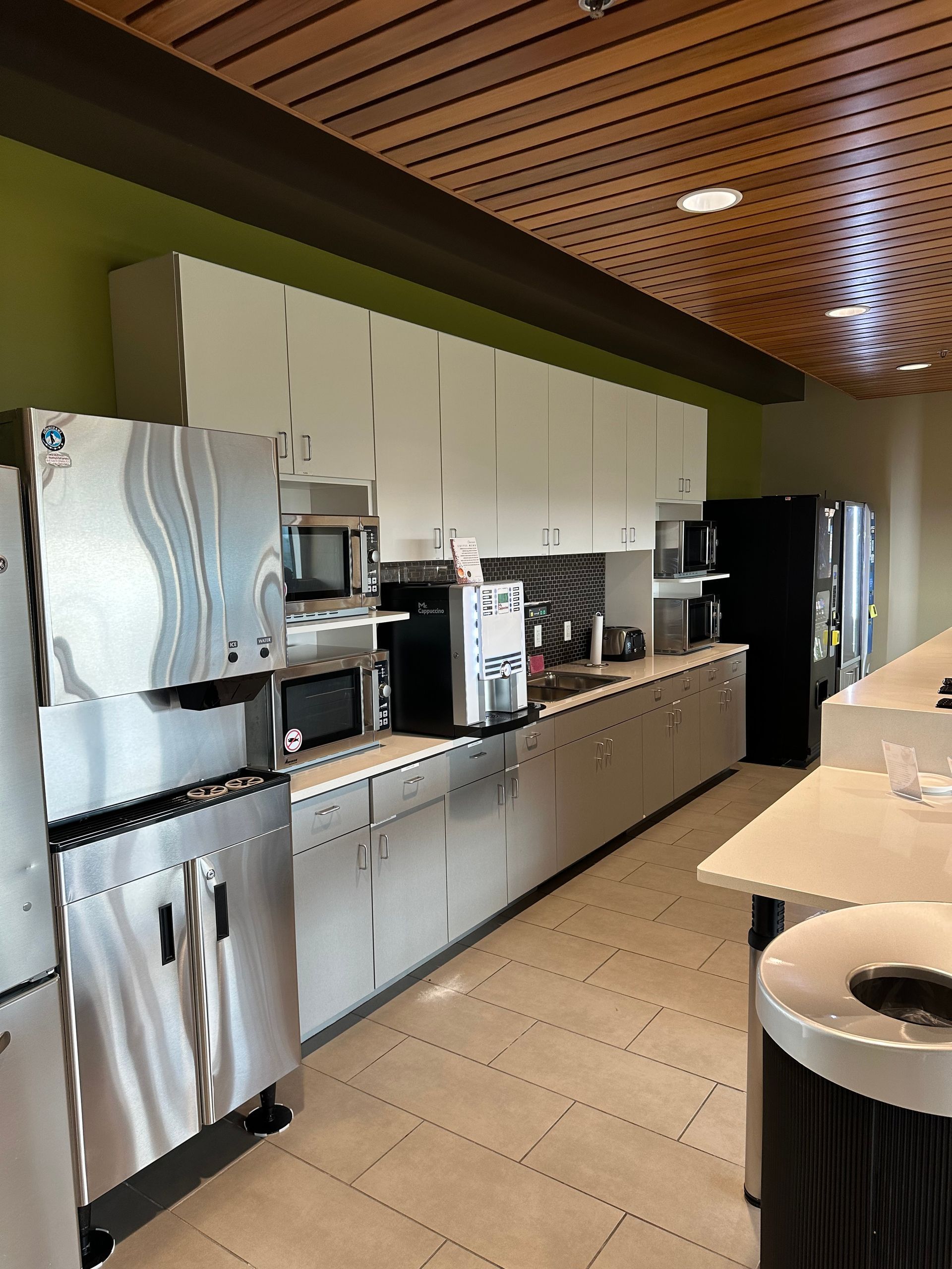 A kitchen with stainless steel appliances and a trash can