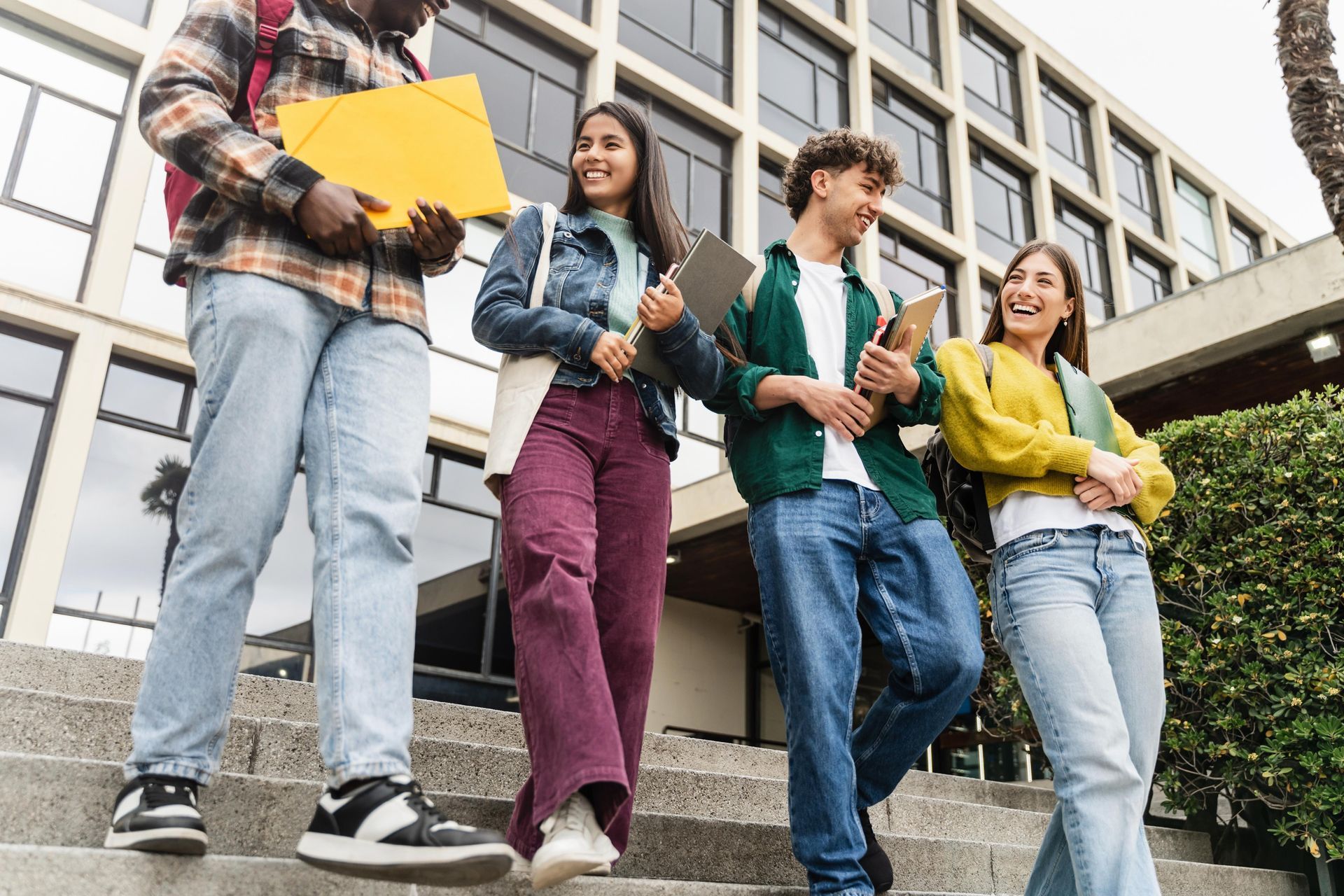 A group of young people are walking down the stairs of a building.