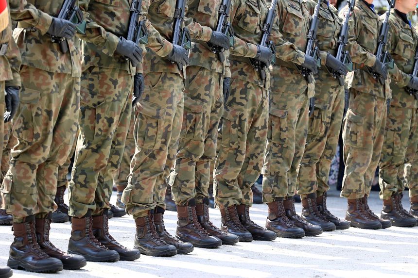 A group of soldiers are standing in a line with their arms crossed.