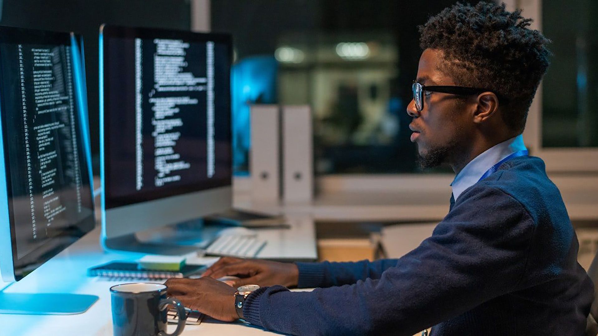 A man is sitting at a desk using a computer.