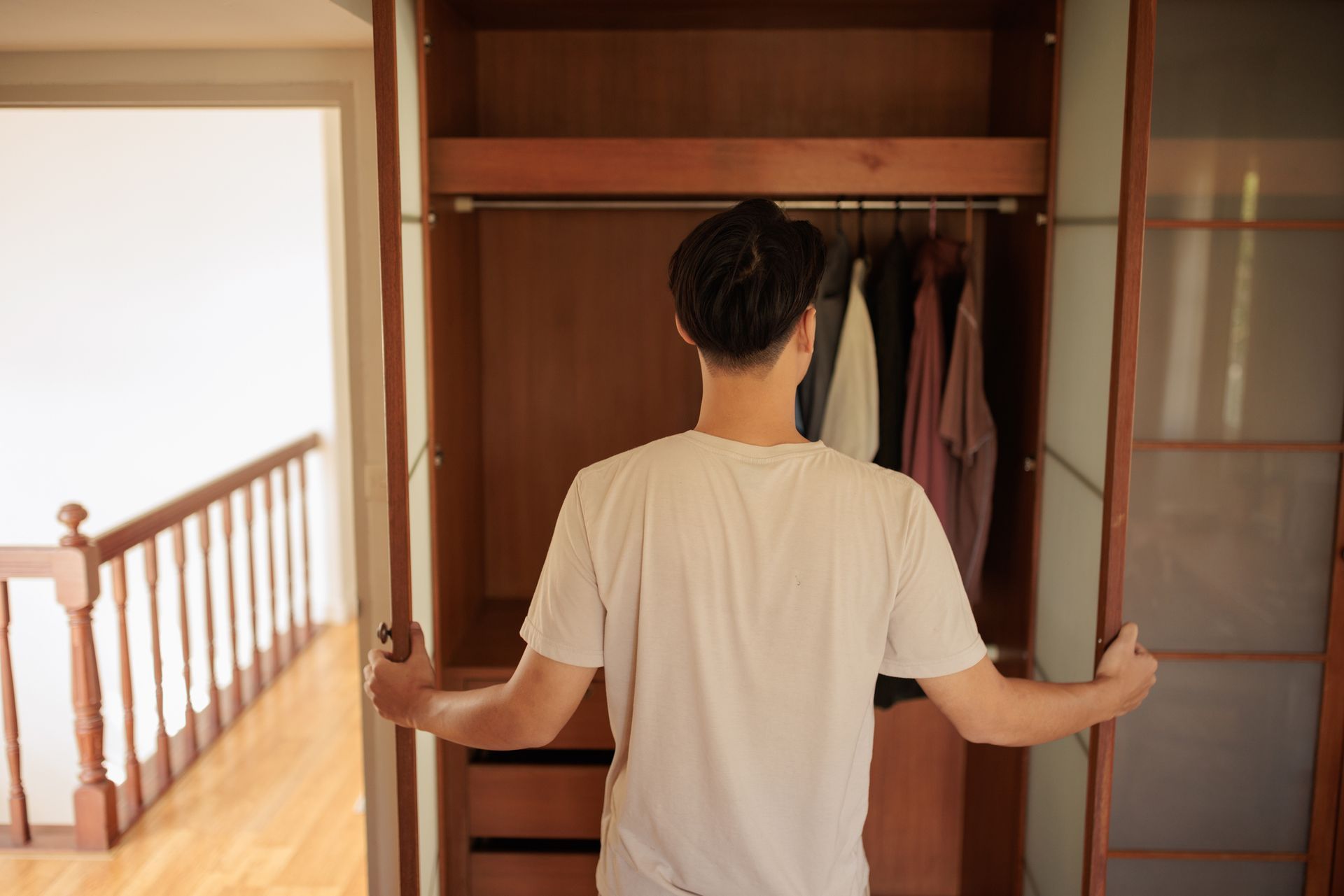 Man preparing for work in front of a built-in wardrobe