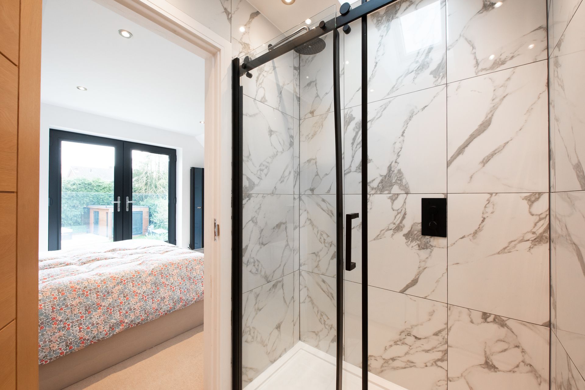Modern bathroom with marble-tiled shower and sliding glass doors. Modern bathroom with marble-tiled shower and sliding glass doors.