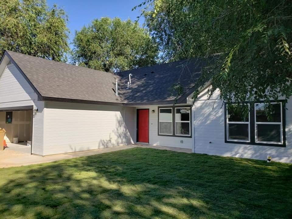 A white house with a red door and a garage.