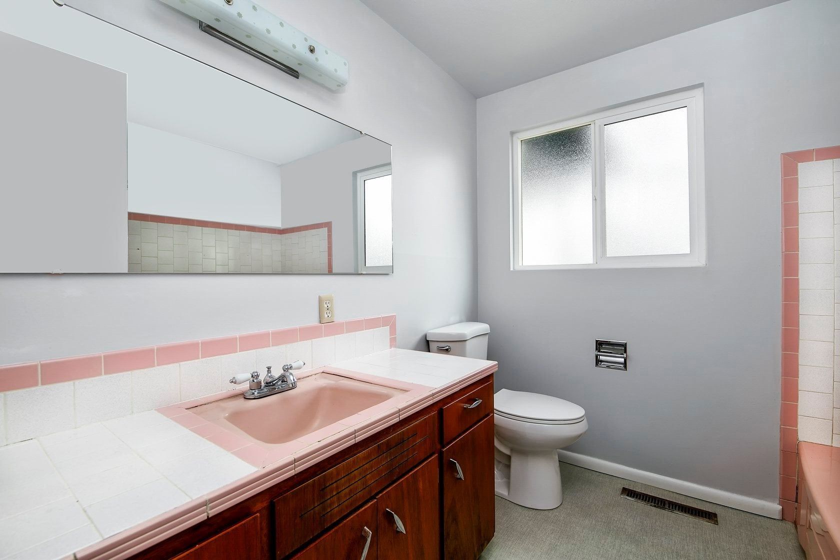 A bathroom with a sink , toilet , and mirror