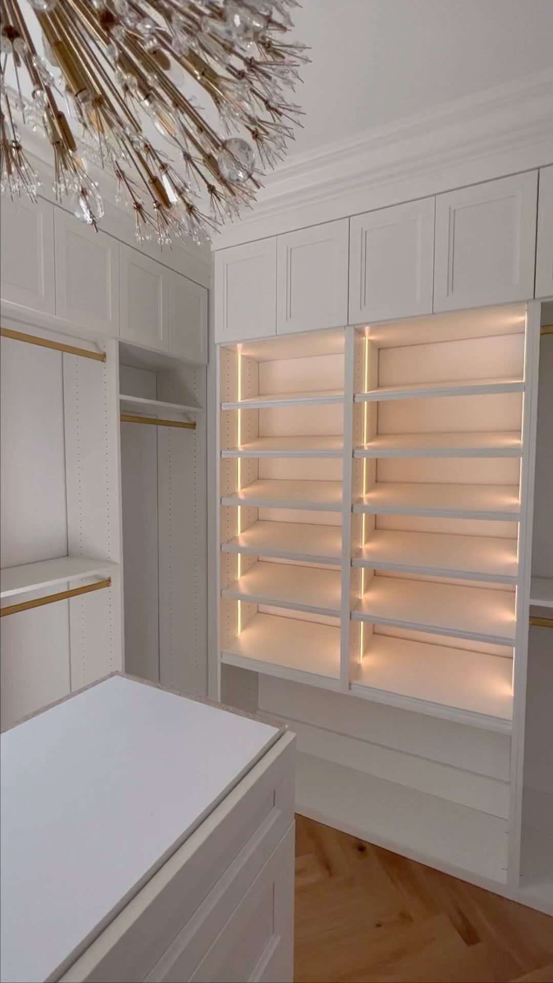 a walk in closet with shelves that are lit up