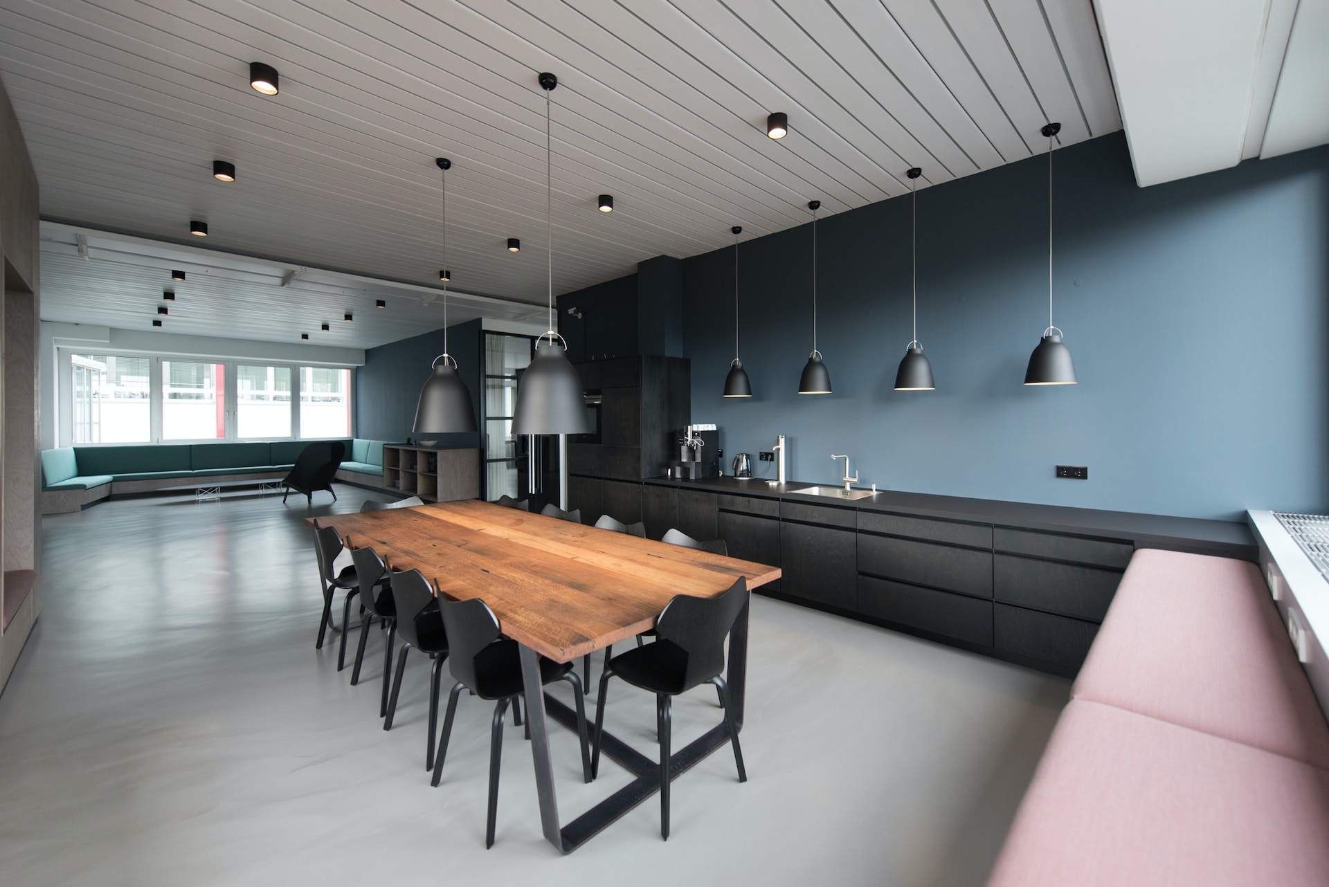 a kitchen with a wooden table and black chairs