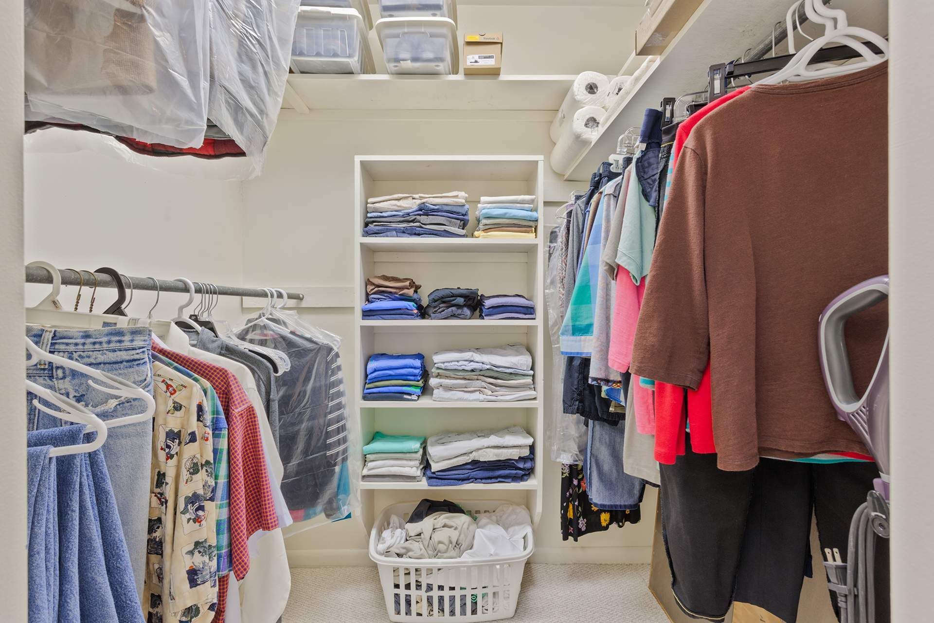 a closet filled with clothes and a laundry basket