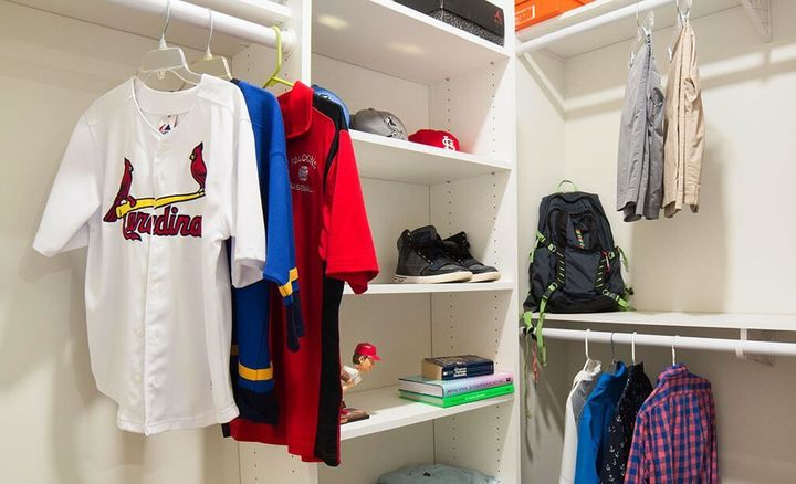 a cardinals baseball jersey hangs in a closet