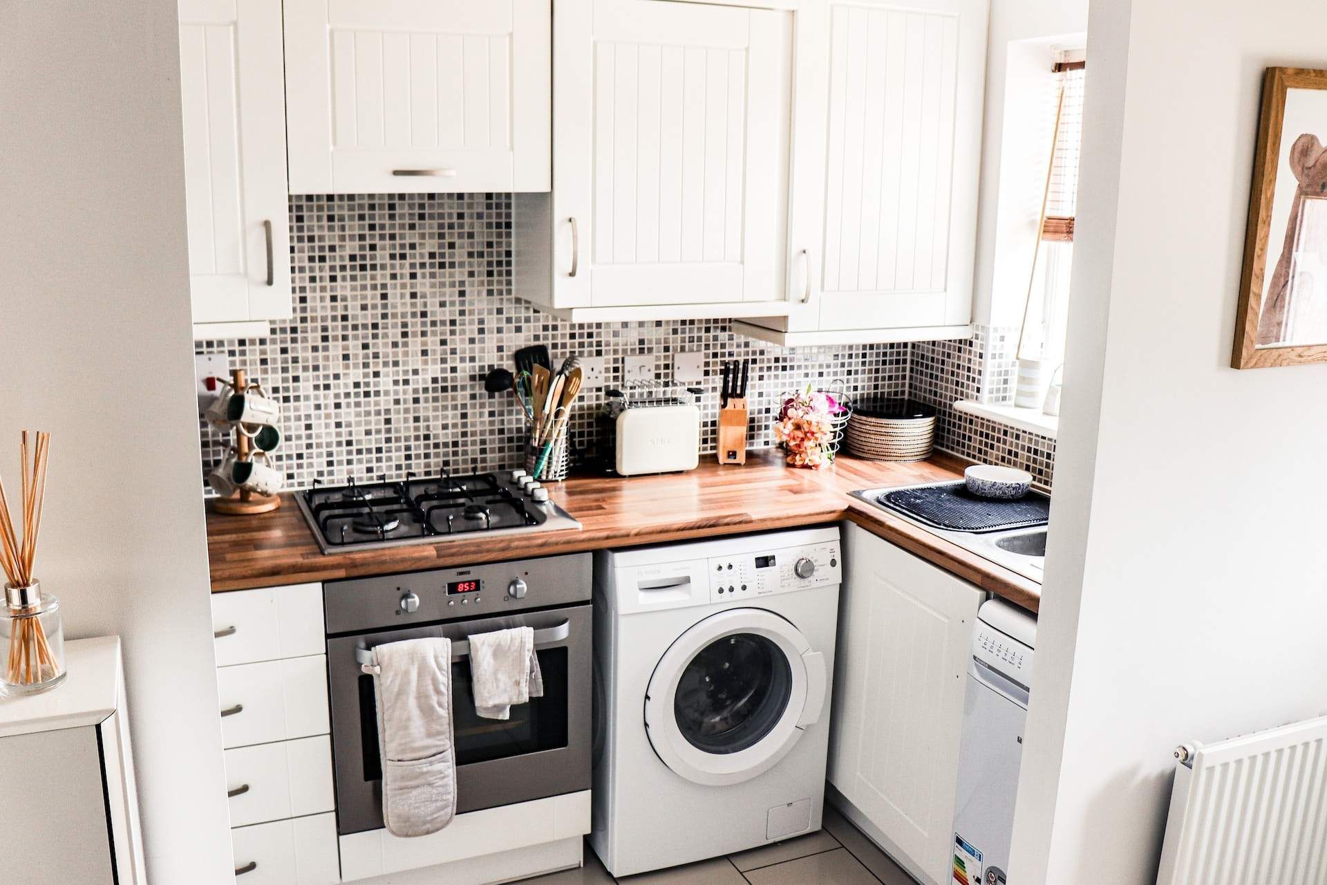 a kitchen with a stove top oven and a washer and dryer