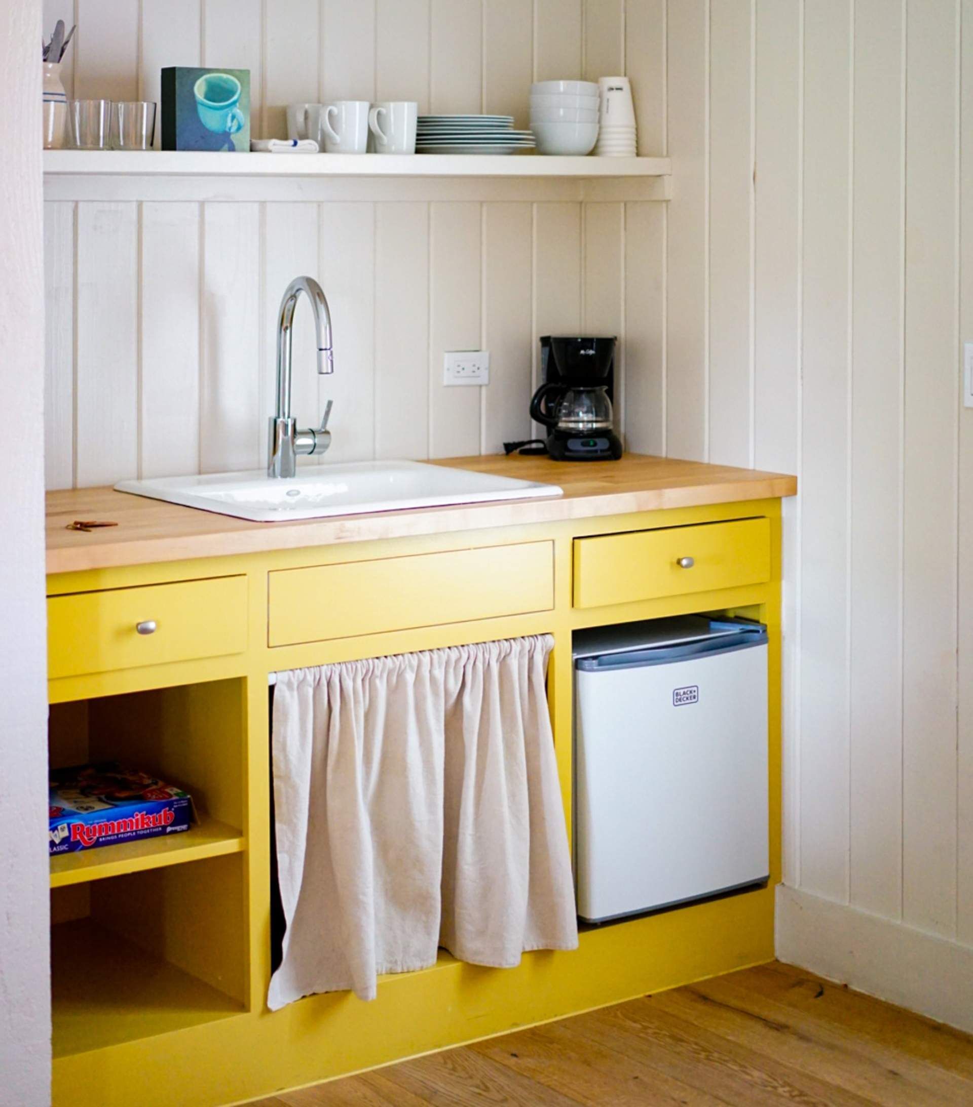 a kitchen with yellow cabinets and a black and decker refrigerator