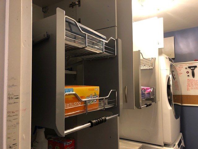 a laundry room with a stack of washers and dryers and a box of scotts dusters