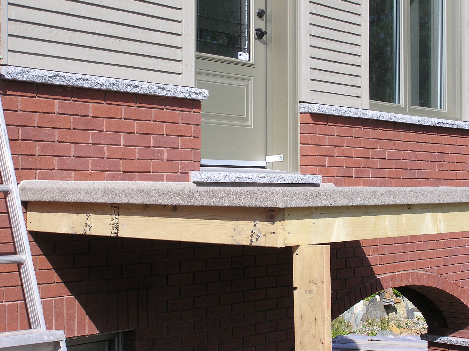 Une maison en briques avec une terrasse en membrane de PVC