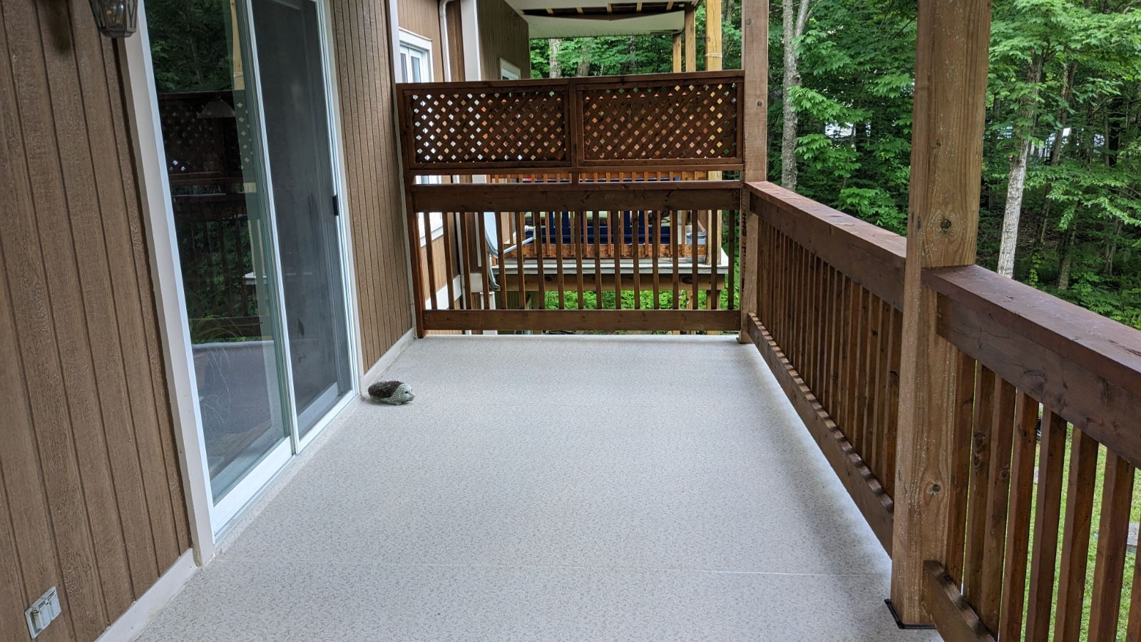 Une terrasse avec une porte coulissante en verre et une balustrade en bois