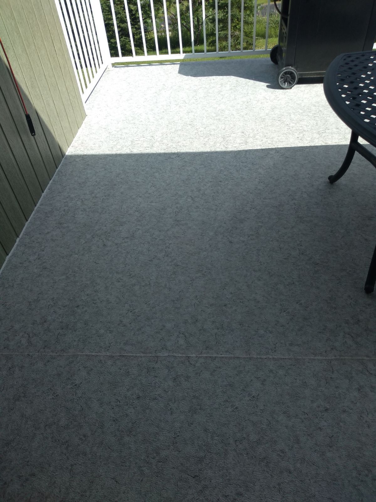 Un balcon en membrane de PVC avec une table, des chaises et un barbecue