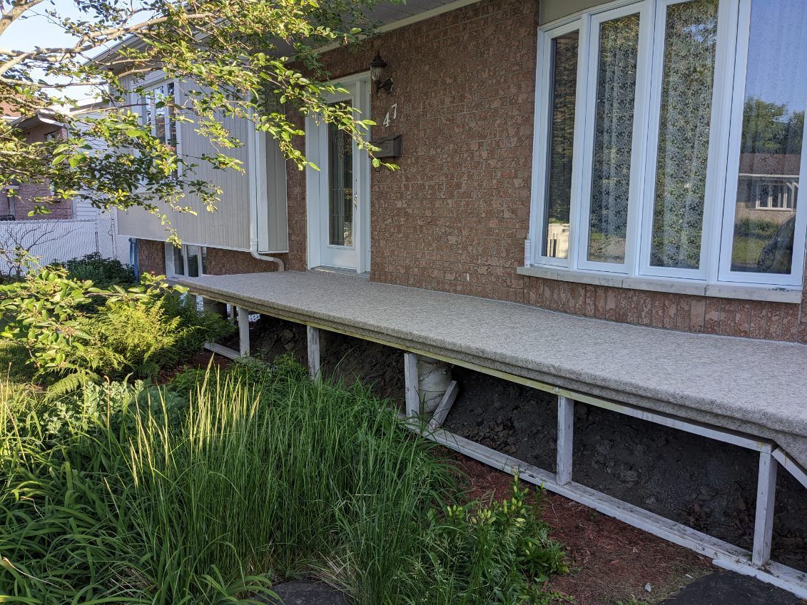Une maison avec un porche et beaucoup d'herbe devant.