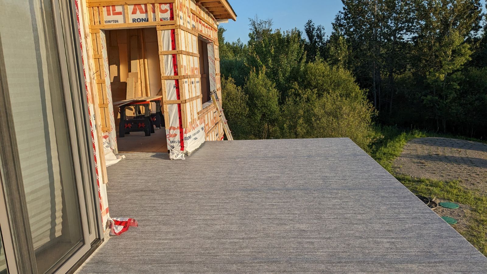 Une maison est en construction avec une grande terrasse devant elle.