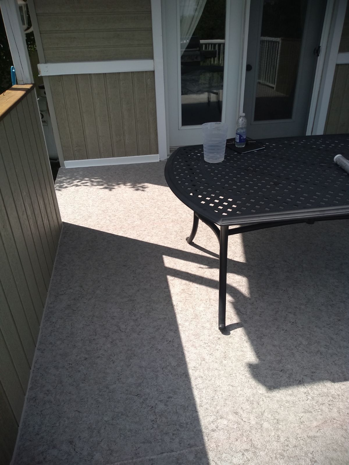 Une table est posée sur une terrasse à côté d'une porte.