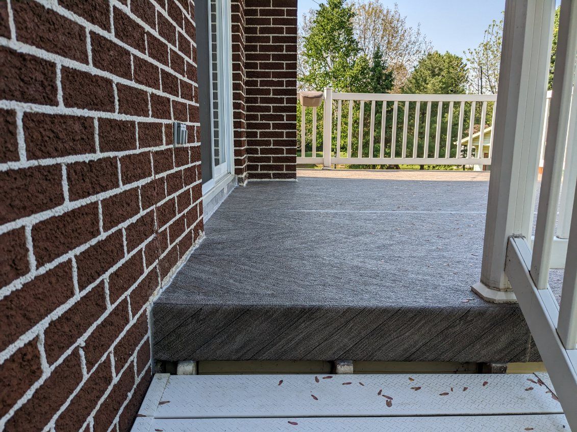 Un bâtiment en briques avec un porche et des escaliers qui y mènent