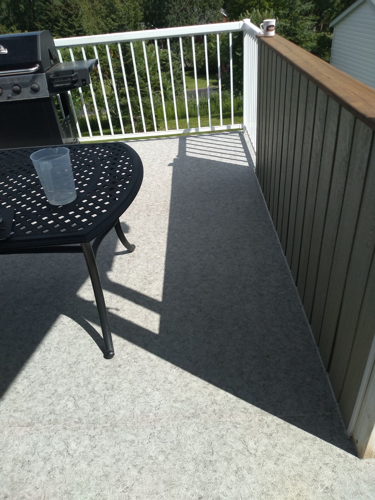 Un balcon avec une table et des chaises et un barbecue.