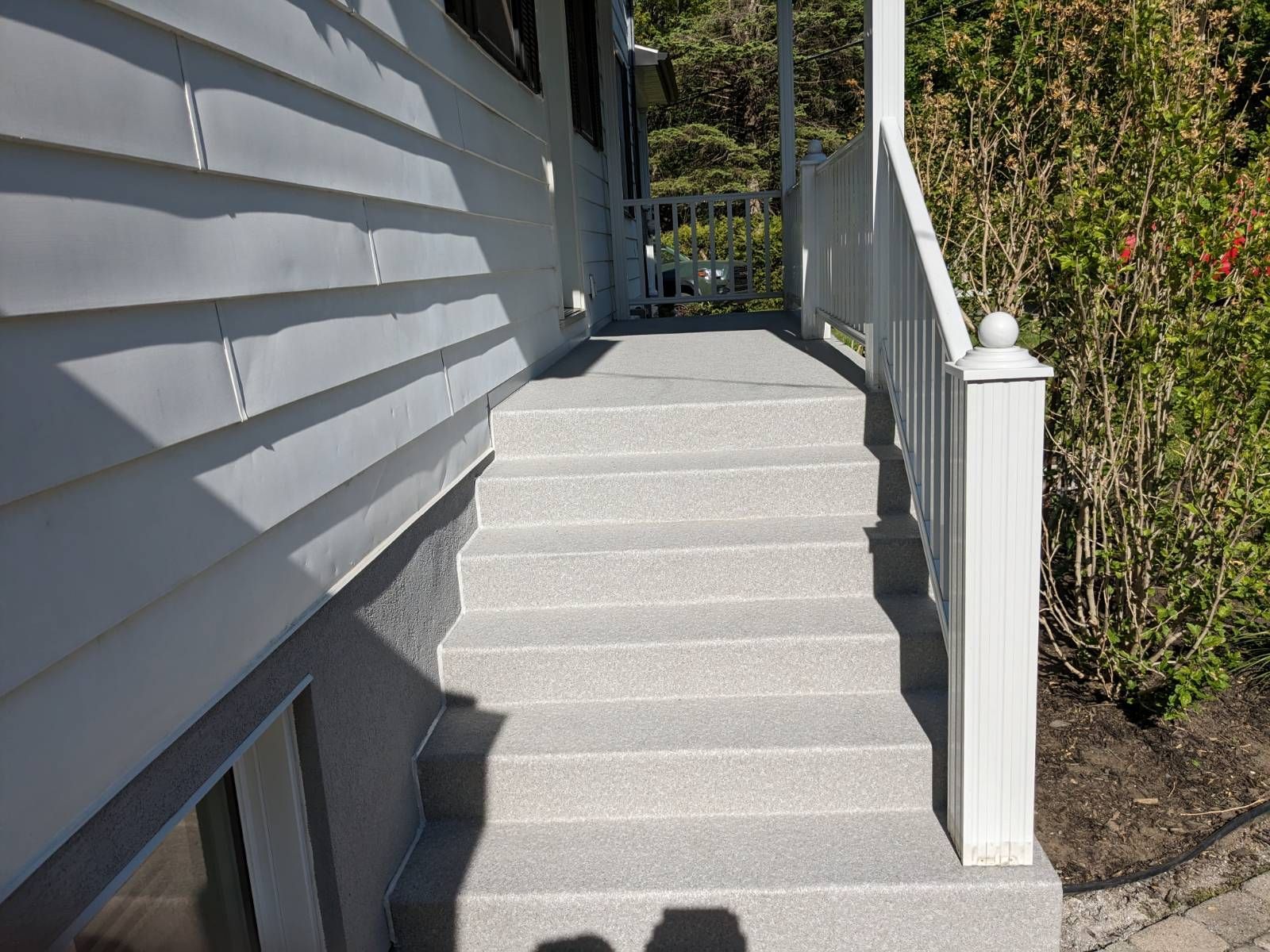 Un escalier menant à un porche avec une balustrade blanche