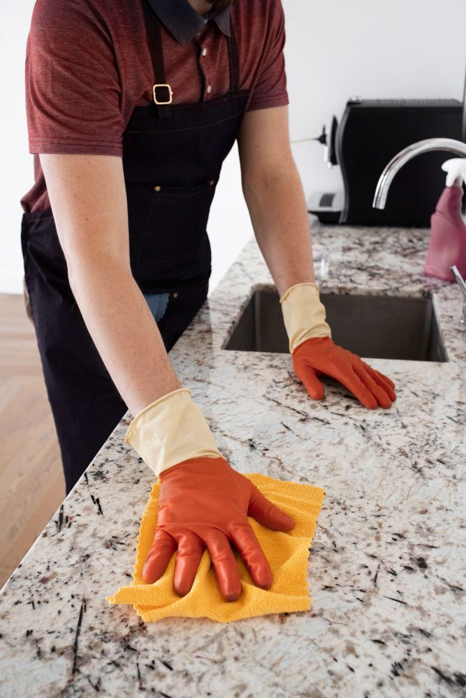 Person using a power polisher on a white marble countertop.