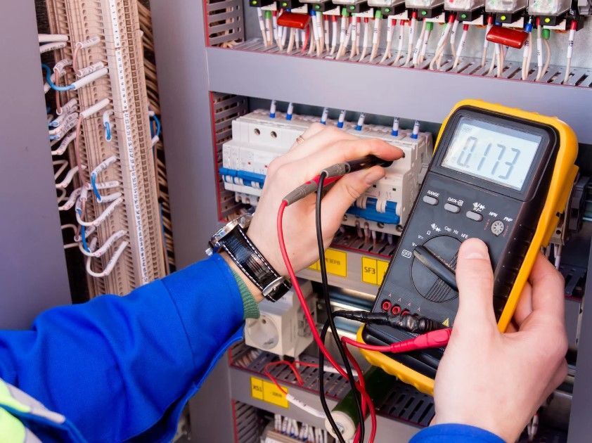 An electrician testing a fuse box in Derby