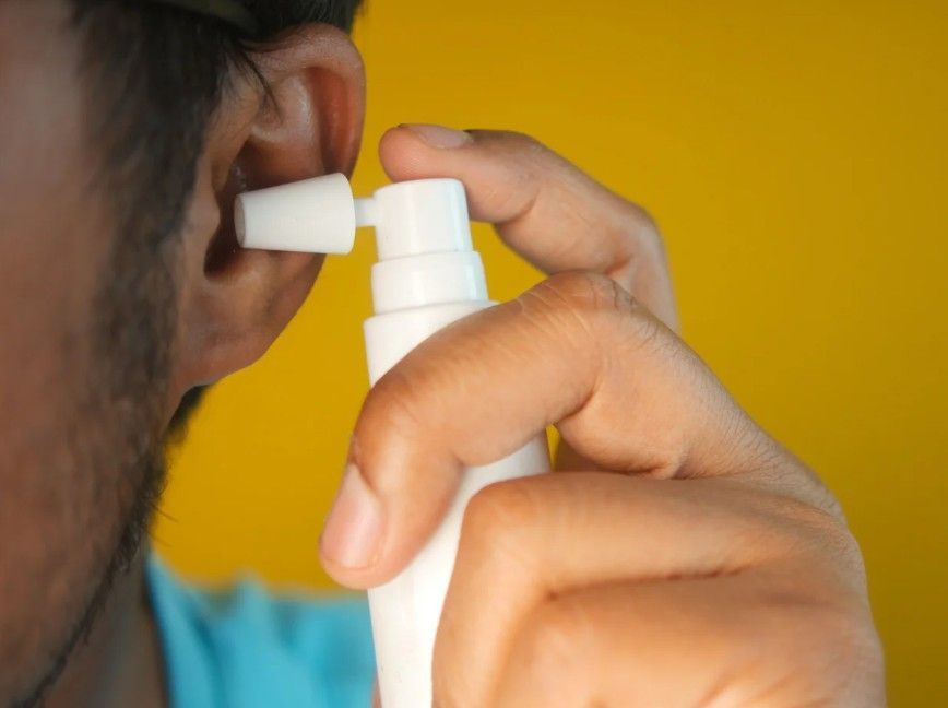spraying olive oil into ear before ear wax removal in Coventry