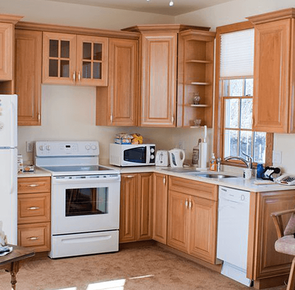 Kitchen with light brown cabinets, white appliances, and a window with blinds.