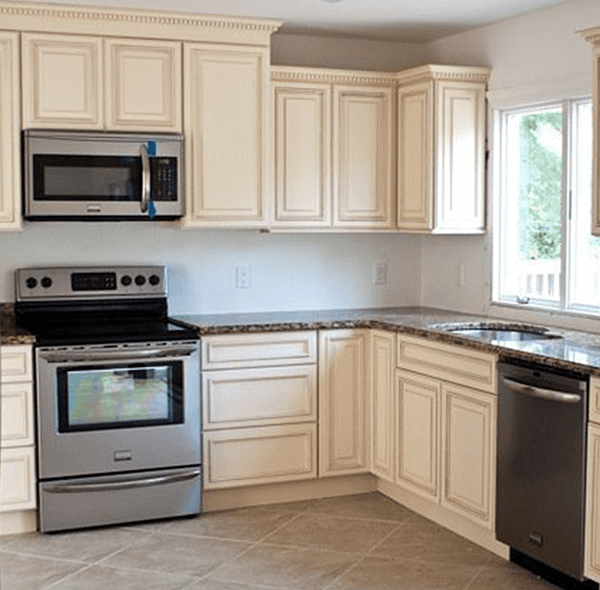Cream-colored kitchen cabinets and stainless steel appliances; granite countertops.