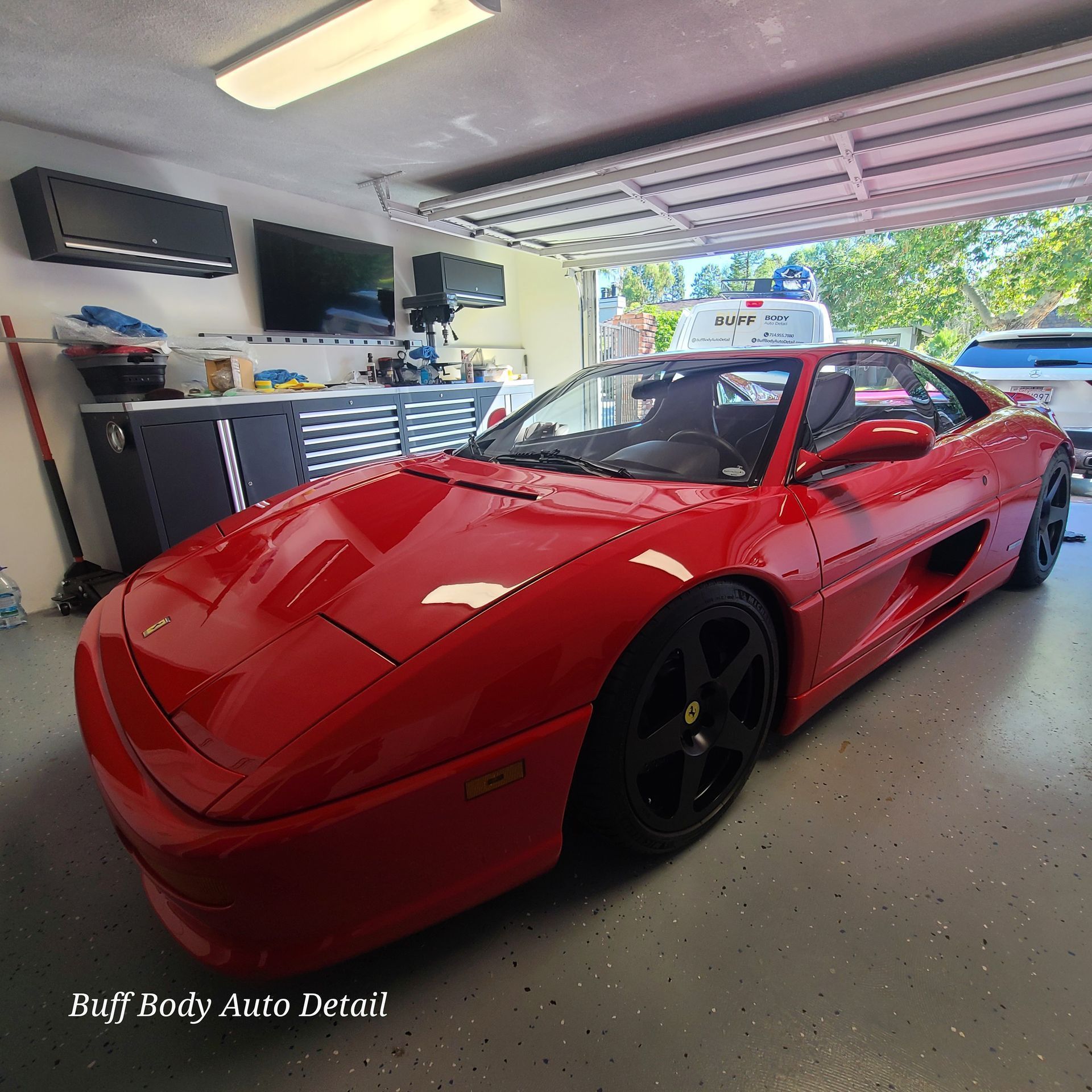 A red sports car is parked in a garage.