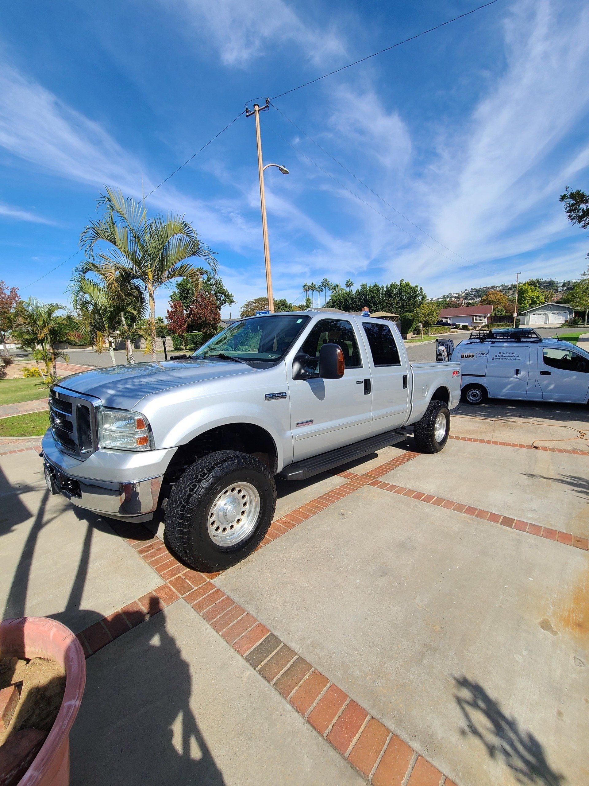 A silver truck is parked in a parking lot