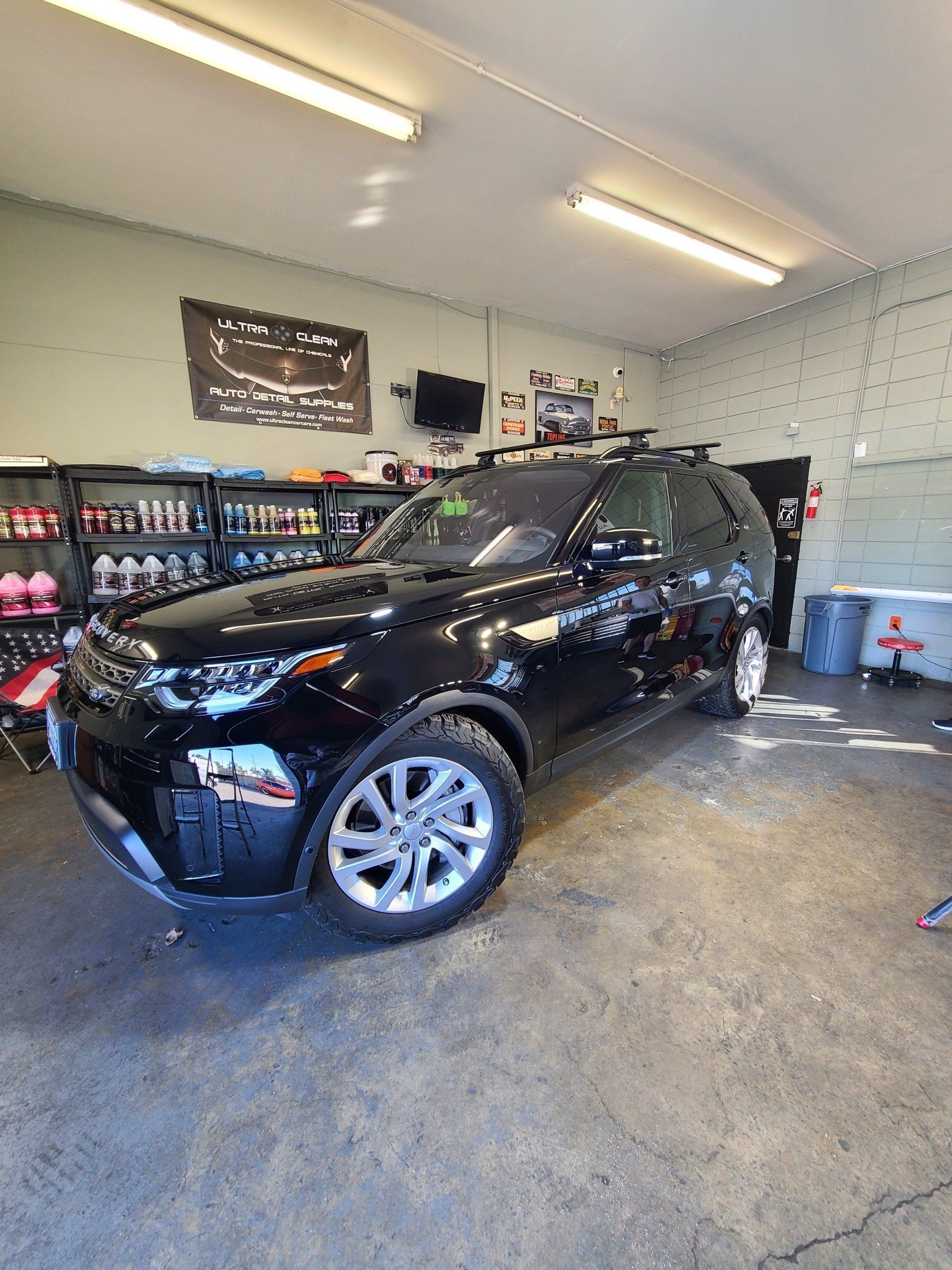 A black land rover discovery is parked in a garage.