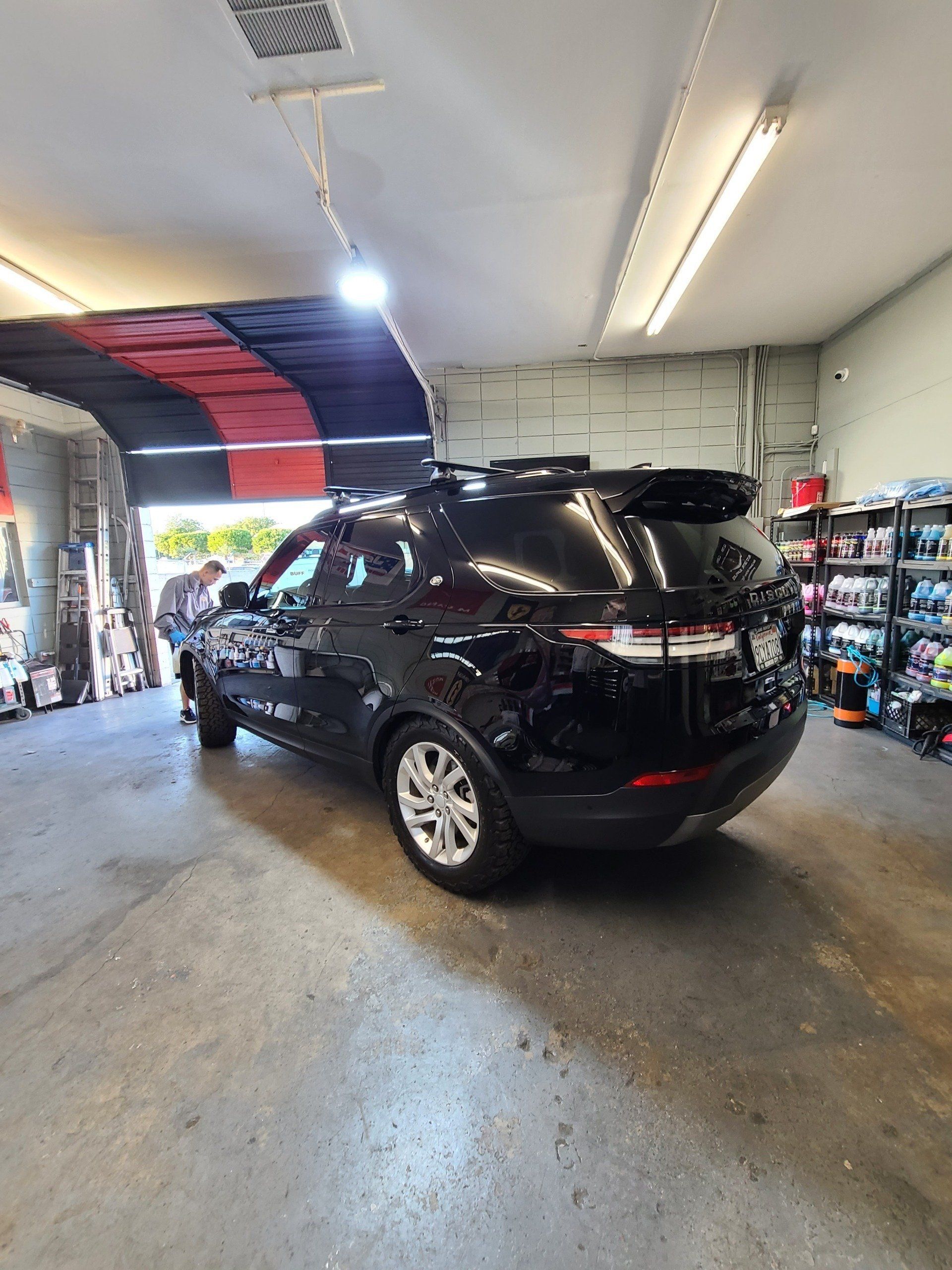 A black suv is parked in a garage.