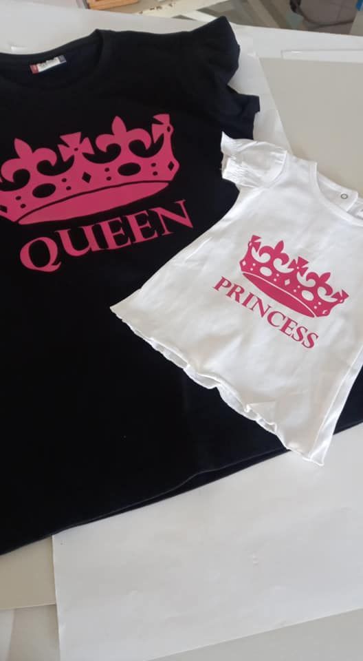 Magliette bianche e nere con disegni di corone rosa. Sulla maglietta nera c'è la scritta 