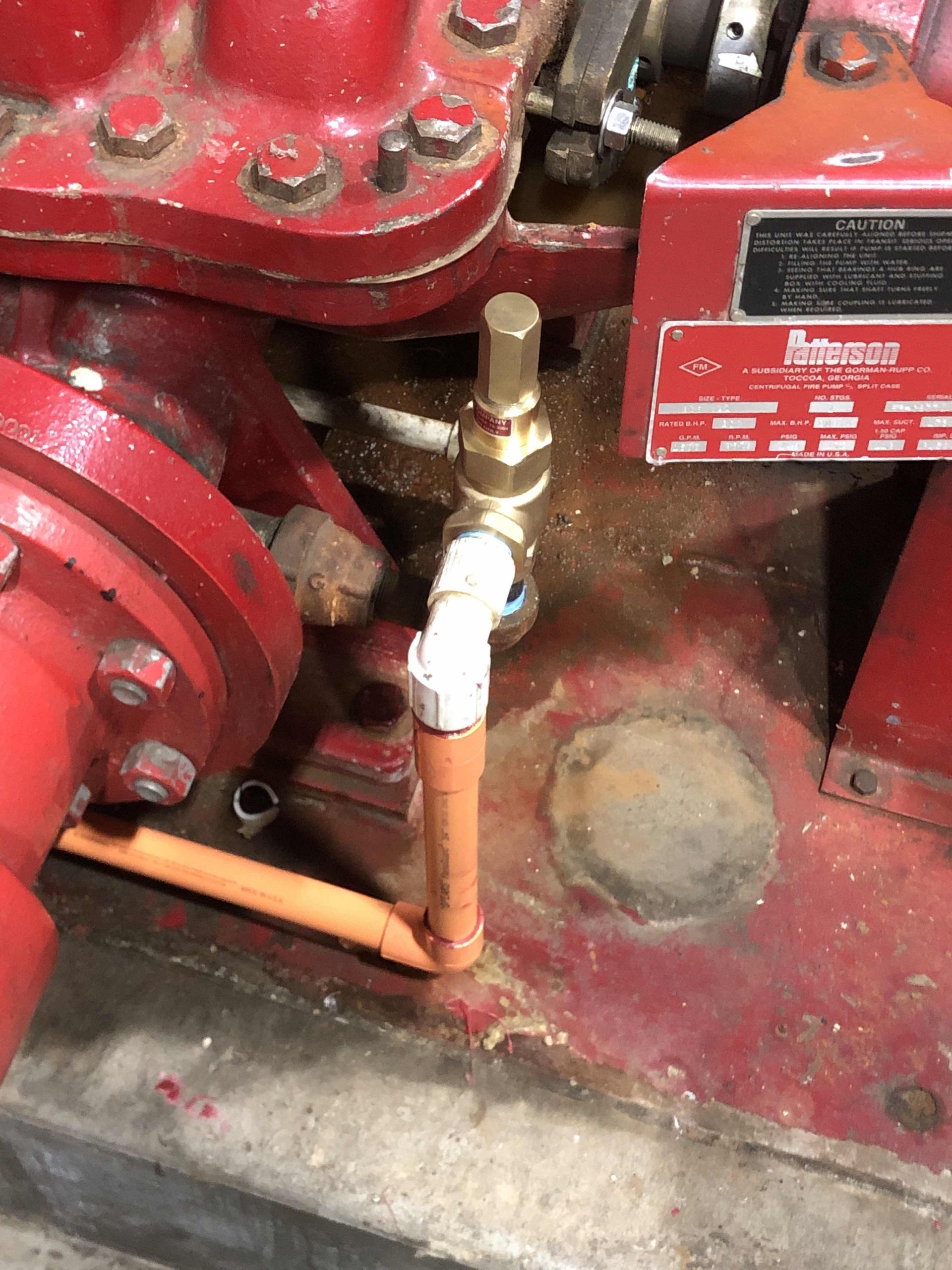 A close up of a red machine with a hose attached to it.