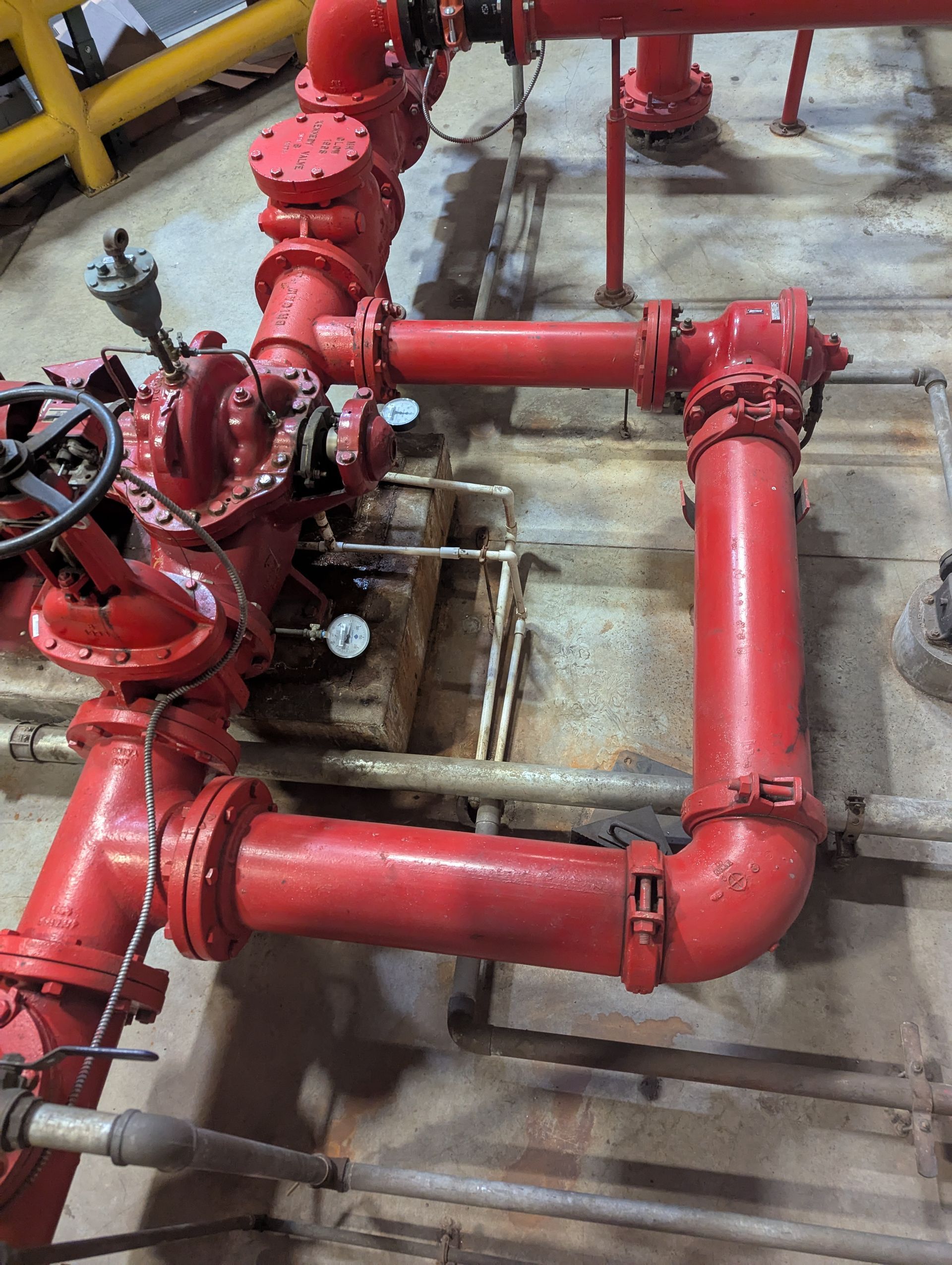 A bunch of red pipes are connected to each other in a room.