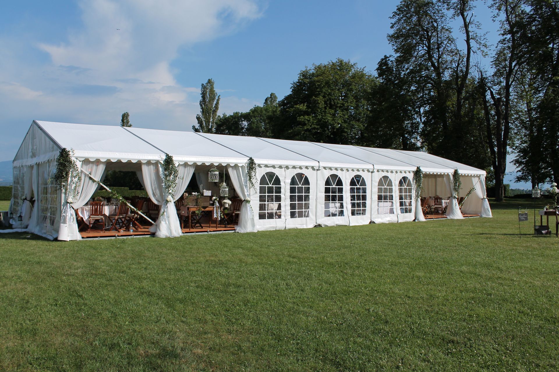 Lac de montagne enneigé avec un long bâtiment blanc en forme d'arche se reflétant dans l'eau calme