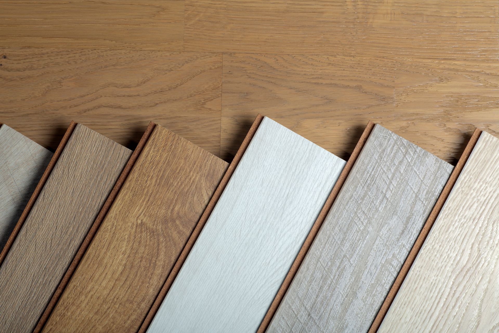 A row of different types of wooden flooring on a wooden table.