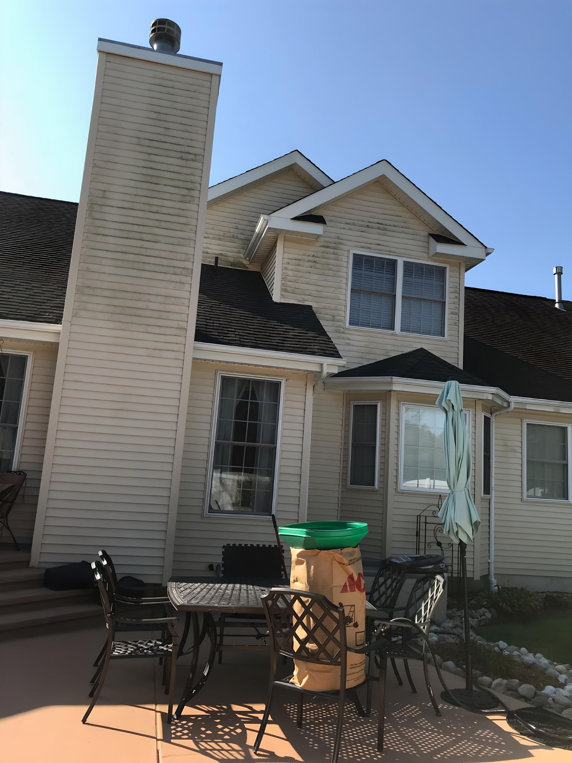 A white house with a large chimney on top of it