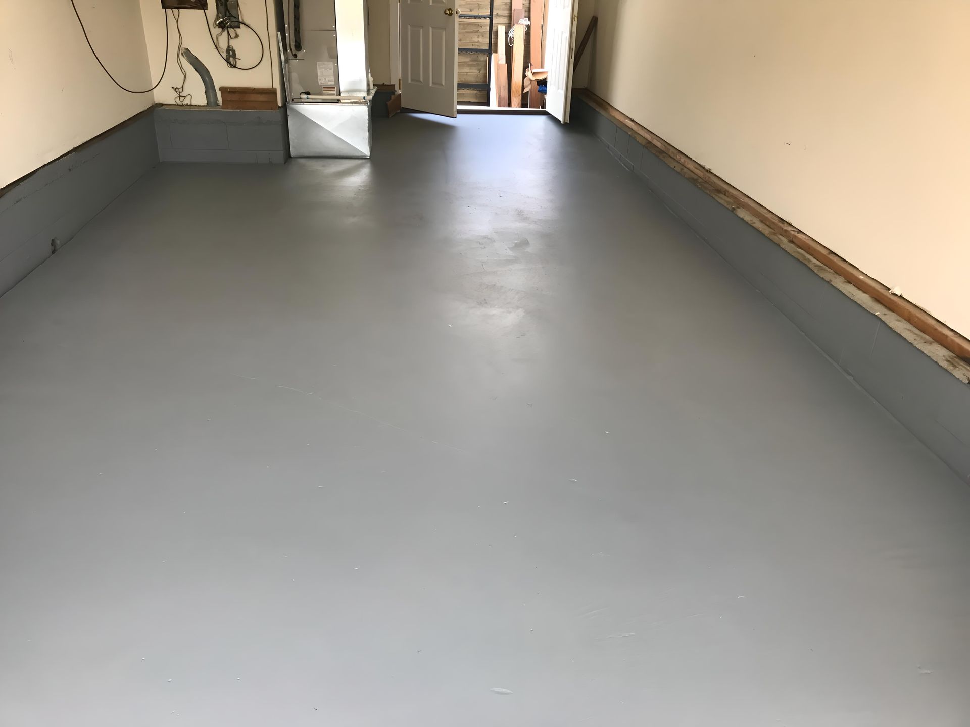 A garage with a gray floor and white walls
