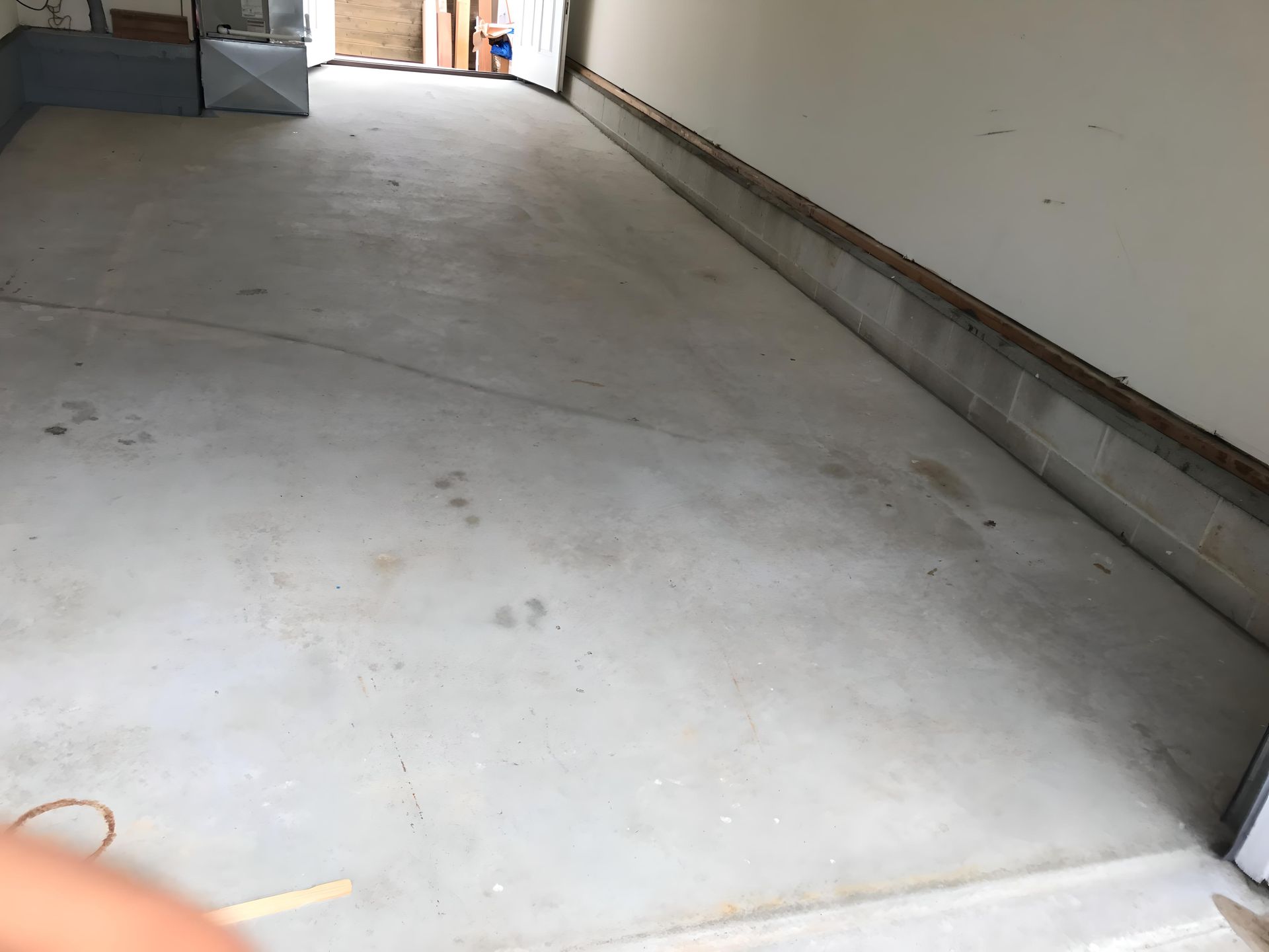 A person is standing in a garage with a concrete floor